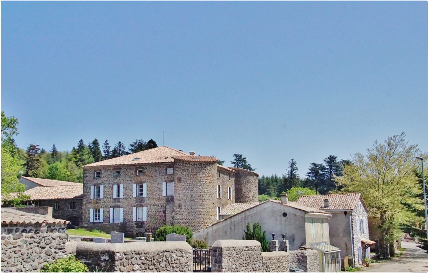 Le château de Berzème et le village, maison forte en basalte sous le ciel du plateau du Coiron